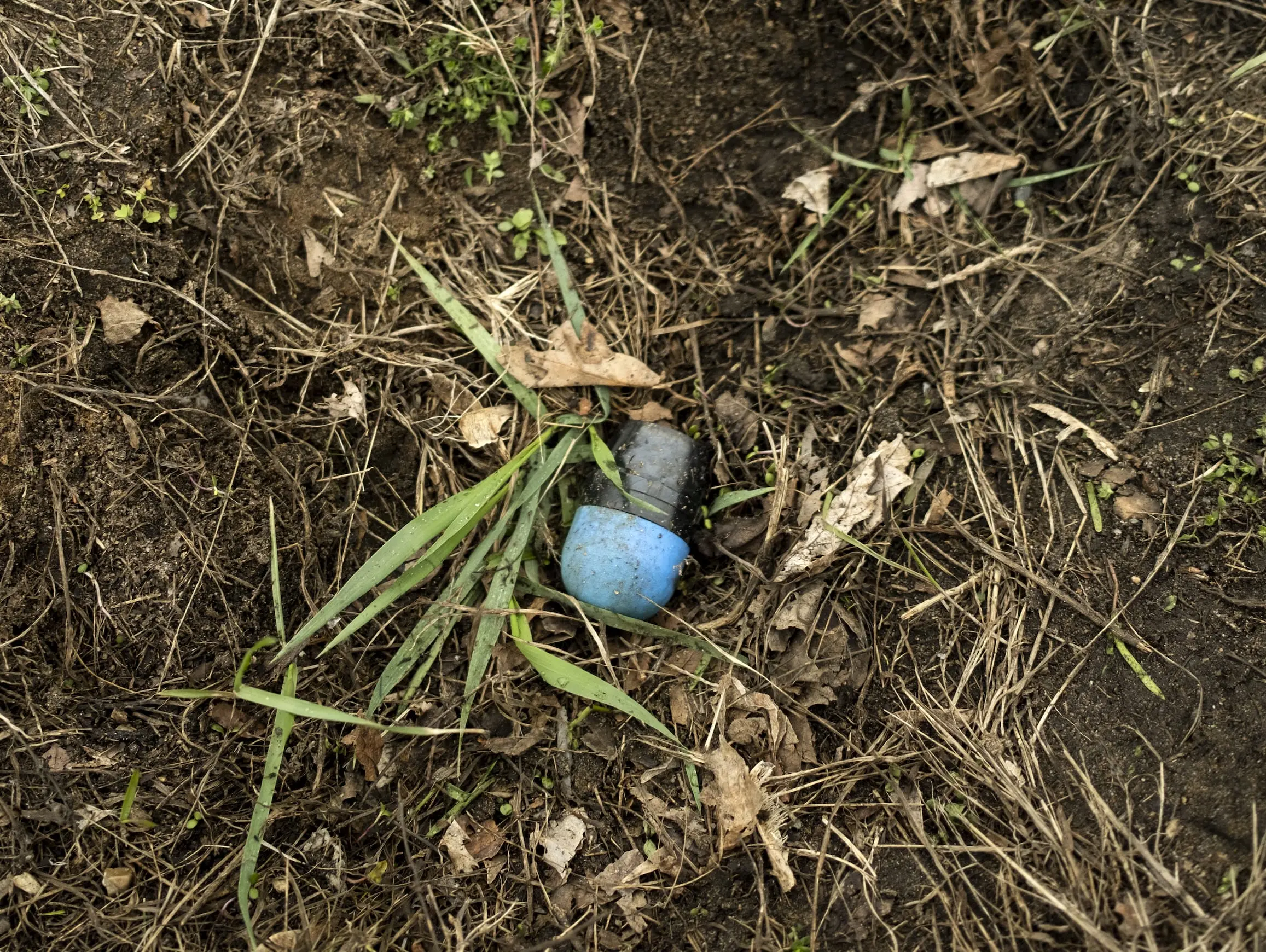 A rubber bullet is on the ground.