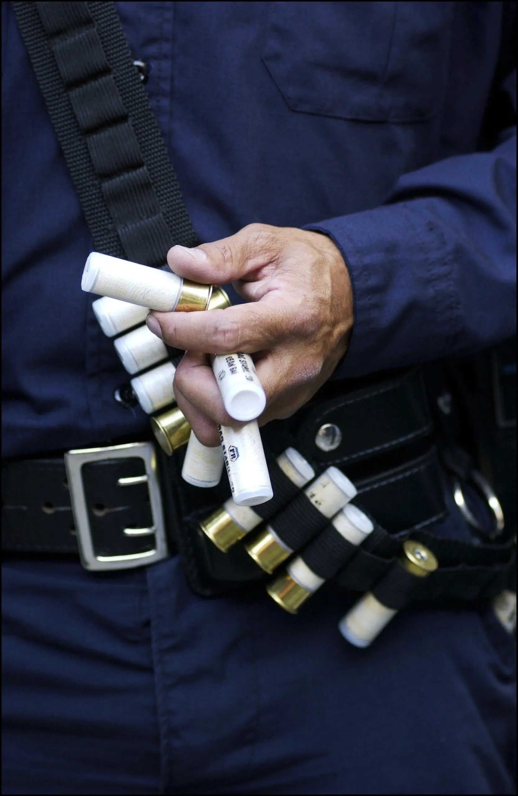 An officer handles bean-bag rounds.